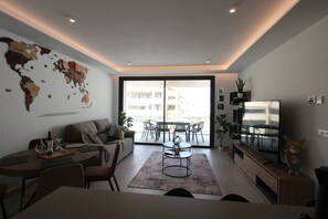 Una sala moderna con un mapa mundial, un sofá, una mesa de comedor y un televisor.