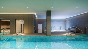 A modern indoor swimming pool with clear water, surrounded by dark tiled walls and a neutral color palette. - Happy Travel Jade Tower (Fuengirola)