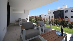 A modern outdoor seating area with a table, two sofas, and a dining set. - Happy Travel Jasmine Higueron (Fuengirola)