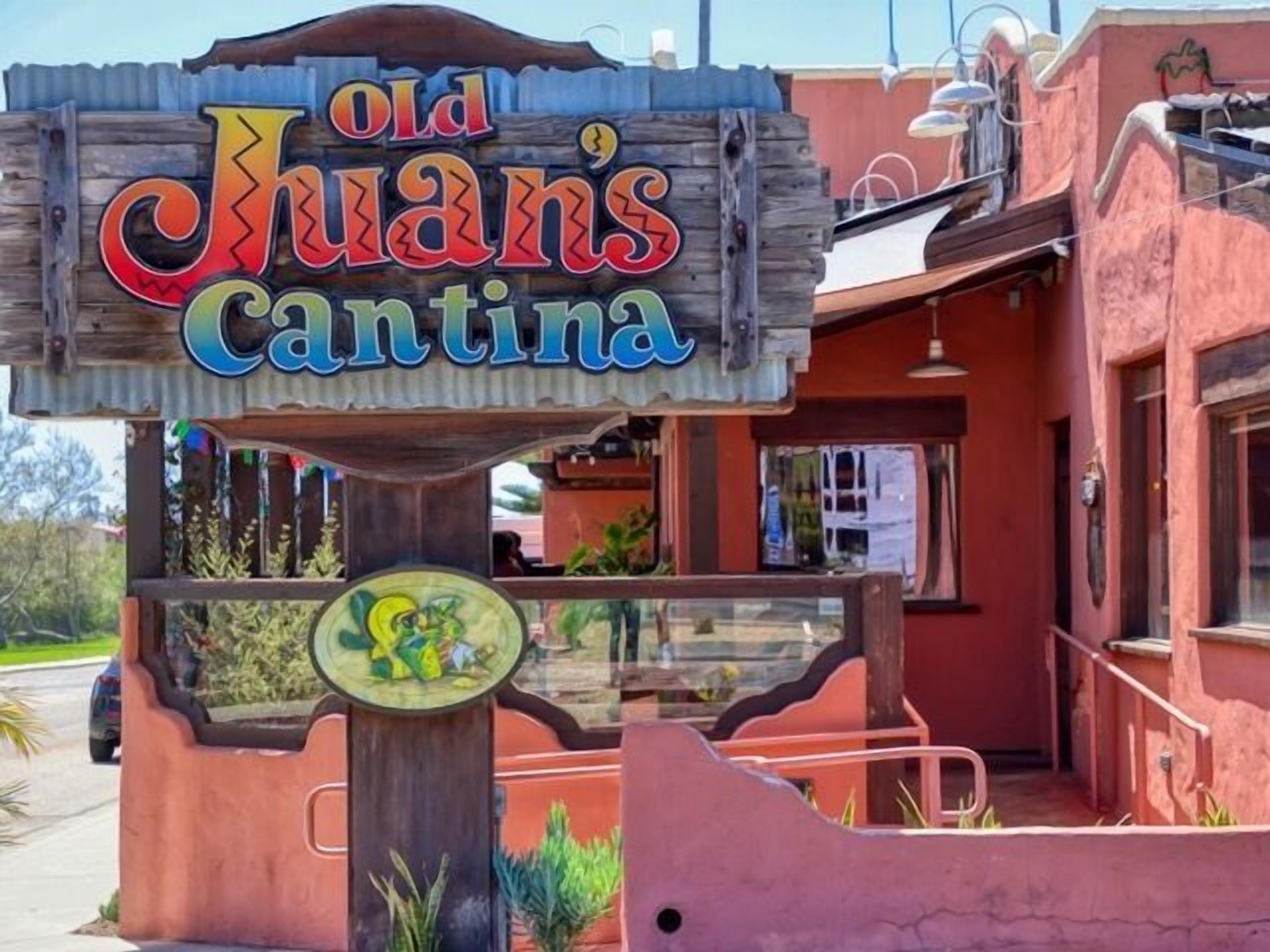 Ein Holzschild mit farbenfroher Schrift für 'Old Juan's Cantina'.