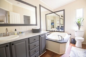 Een moderne badkamer met een grote spiegel, een wastafel en een toilet.