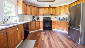 Une cuisine dotée de meubles en bois, d’appareils électroménagers en acier inoxydable et d’un plan de travail en granit.