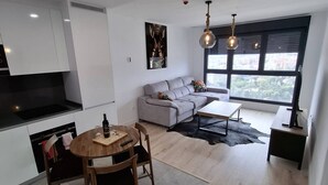 A modern living space with a kitchen, dining area, and seating area. - Happy Travel Urban Sky 26A (Málaga)