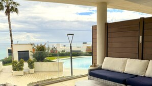 A terrace with wicker furniture, a pool, and a view of the ocean. - Happy Travel Panoramica (Fuengirola)