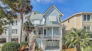 Ein zweistöckiges Haus mit Balkon, Garage und einer Treppe, die zum zweiten Stock führt.