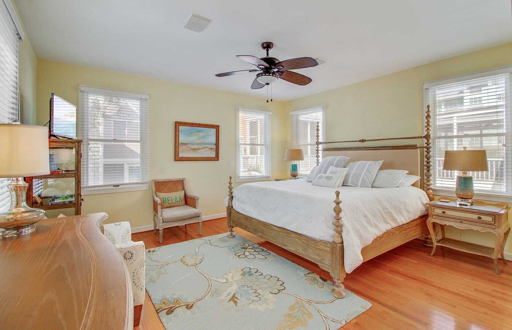 A bedroom with a wooden bed, a ceiling fan, and a window with blinds.
