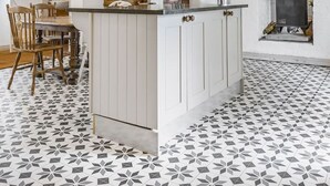 A kitchen with white cabinets, a central island, and a patterned tile floor. - 3 Bedroom Country Cottage with Private Fenced Garden (Shifnal)