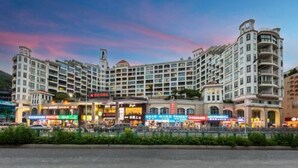 Un hôtel à plusieurs étages doté d’un atrium central, de nombreux balcons et de divers commerces de détail situés au rez-de-chaussée.