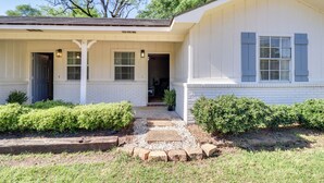A single-story house with a front porch, a covered entryway, and a small front yard with a gravel pathway and shrubs. - Walk to Eats & Entertainment: Home in Brookhaven (Brookhaven)
