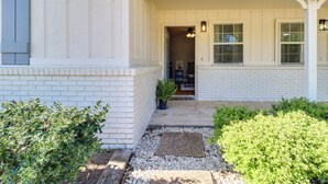 A house with a white exterior, a front porch, and a pathway leading to the entrance. - Walk to Dining & Shops: Dtwn Brookhaven Home! (Brookhaven)