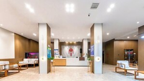 Un espace d’accueil moderne avec un comptoir central, deux colonnes et des sièges disposés de part et d’autre.