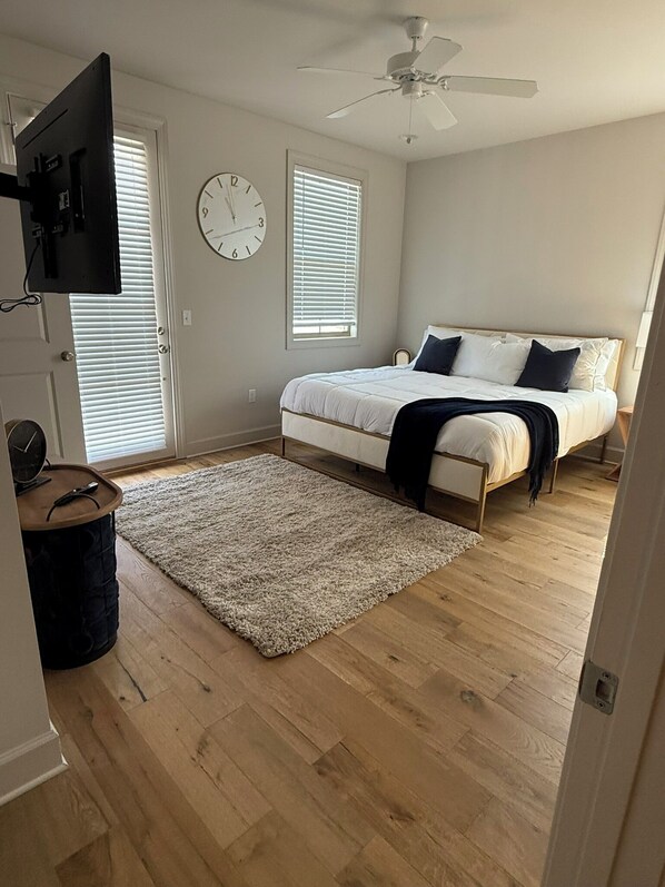 Cozy retreat with a comfortable bed, ceiling fan, and large wall clock.