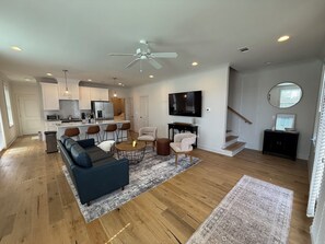 Relax in this spacious living area with a sofa, coffee table, and armchairs, perfect for unwinding.