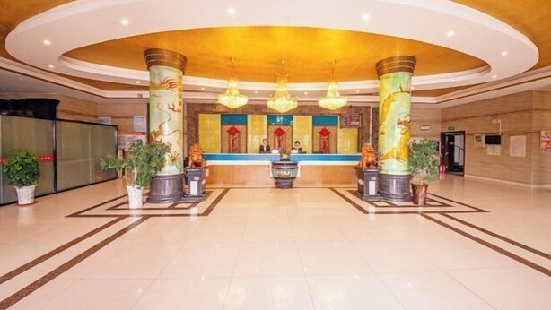 A hotel lobby with a reception desk, decorative pillars, and a tiled floor. - Shui Yun Jian Xinghualou Hotel (Chizhou)