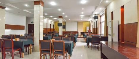Una sala de conferencias con mesas y sillas dispuestas para reuniones.