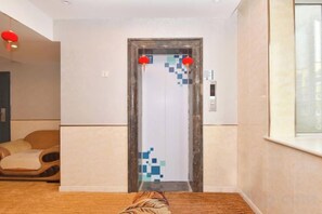 A hotel room with a bed, a door with a digital lock, and a window. - Shui Yun Jian Xinghualou Hotel (Chizhou)