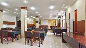 A spacious hotel dining area with multiple tables and chairs, a long counter, and a projection screen. - Shui Yun Jian Xinghualou Hotel (Chizhou)