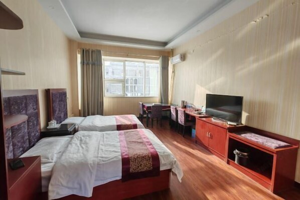 A hotel room with two beds, a desk, a television, and a window with curtains. - Damaoqi Haode Business Hotel (Damao Banner)