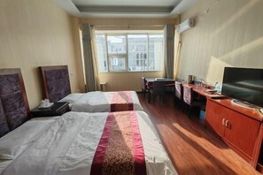 A hotel room with two beds, a desk with a chair, a television, and a window with curtains. - Damaoqi Haode Business Hotel (Damao Banner)
