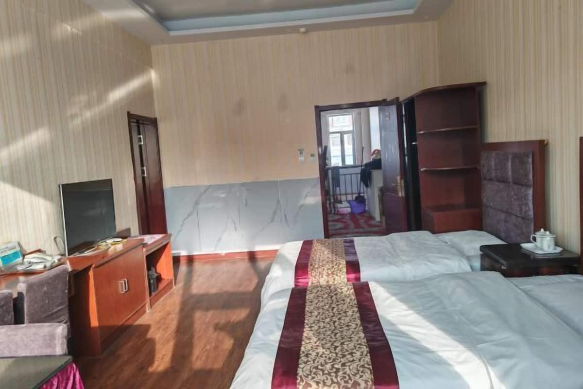Una habitación de hotel con cama, escritorio, televisor y armario.
