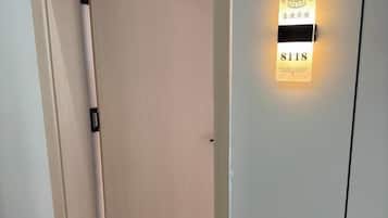 A door with a lighted sign above it, displaying the number 8118.
