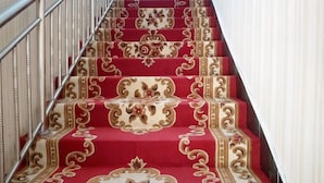 Una escalera con diseños de alfombra elaborados y barandillas de metal.