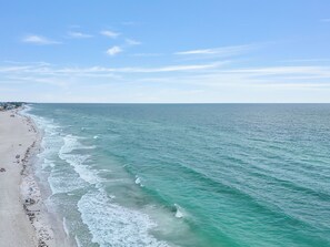 Una playa con aguas turquesas cristalinas y una orilla arenosa.