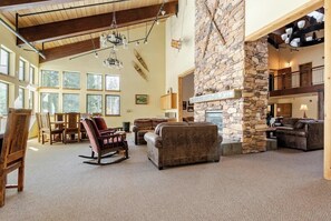 Cozy living area with a stone fireplace, comfortable seating, and a view of the outdoors.