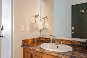 Bathroom features a sink, mirror, and towel rack.