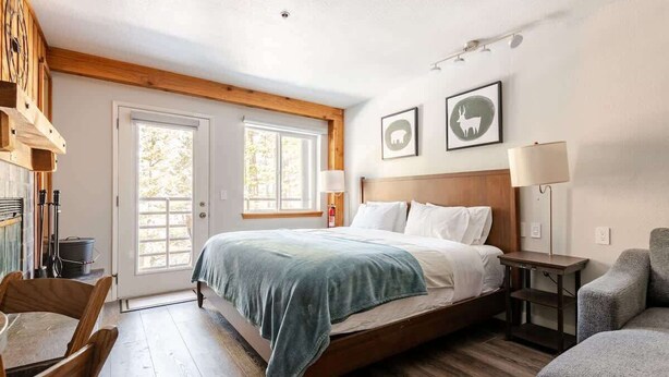 Un dormitorio con cama, escritorio, silla y sofá.