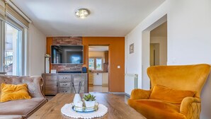 A living room with a wooden coffee table, a sofa, and an orange armchair. - Awesome home in Pula with WiFi (Pula)