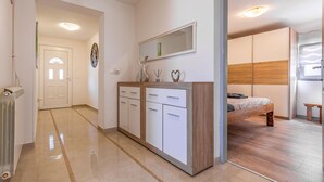 A modern bedroom with a wooden bed, a bedside table, and a large mirror above a dresser. - Awesome home in Pula with WiFi (Pula)