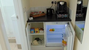 A compact kitchen with a refrigerator, a coffee maker, and a kettle. - The Three Crowns (Loughborough)