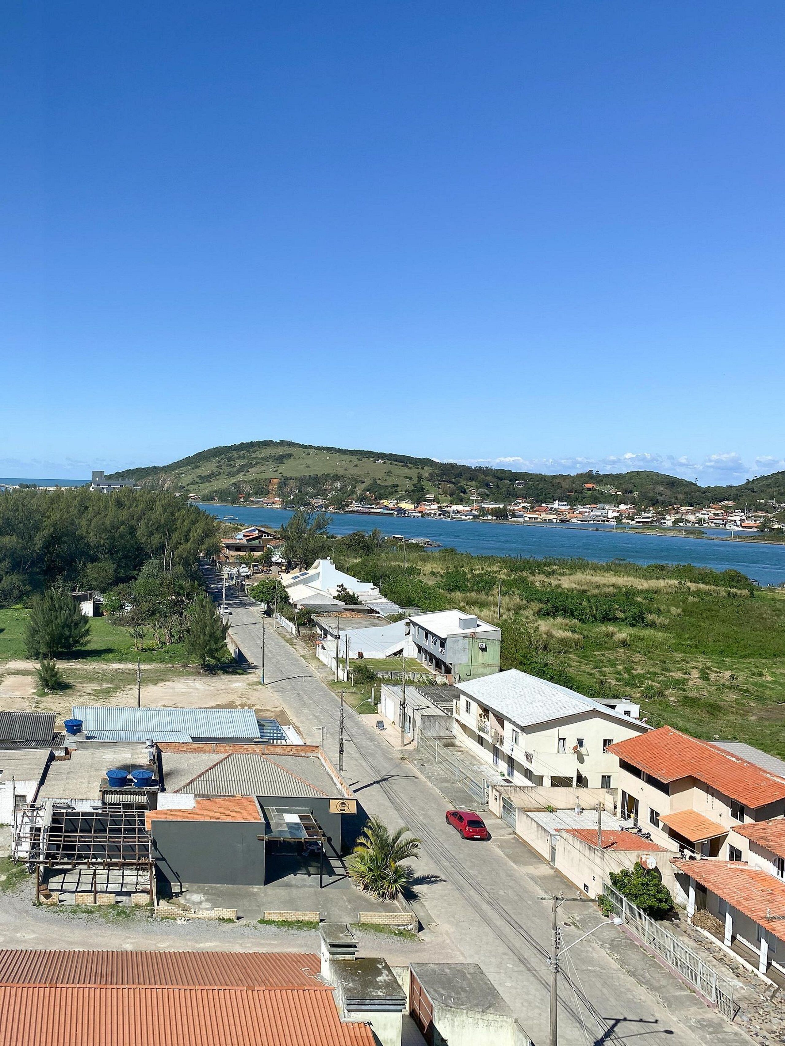 Une ville côtière avec des bâtiments, une route et une étendue d’eau.