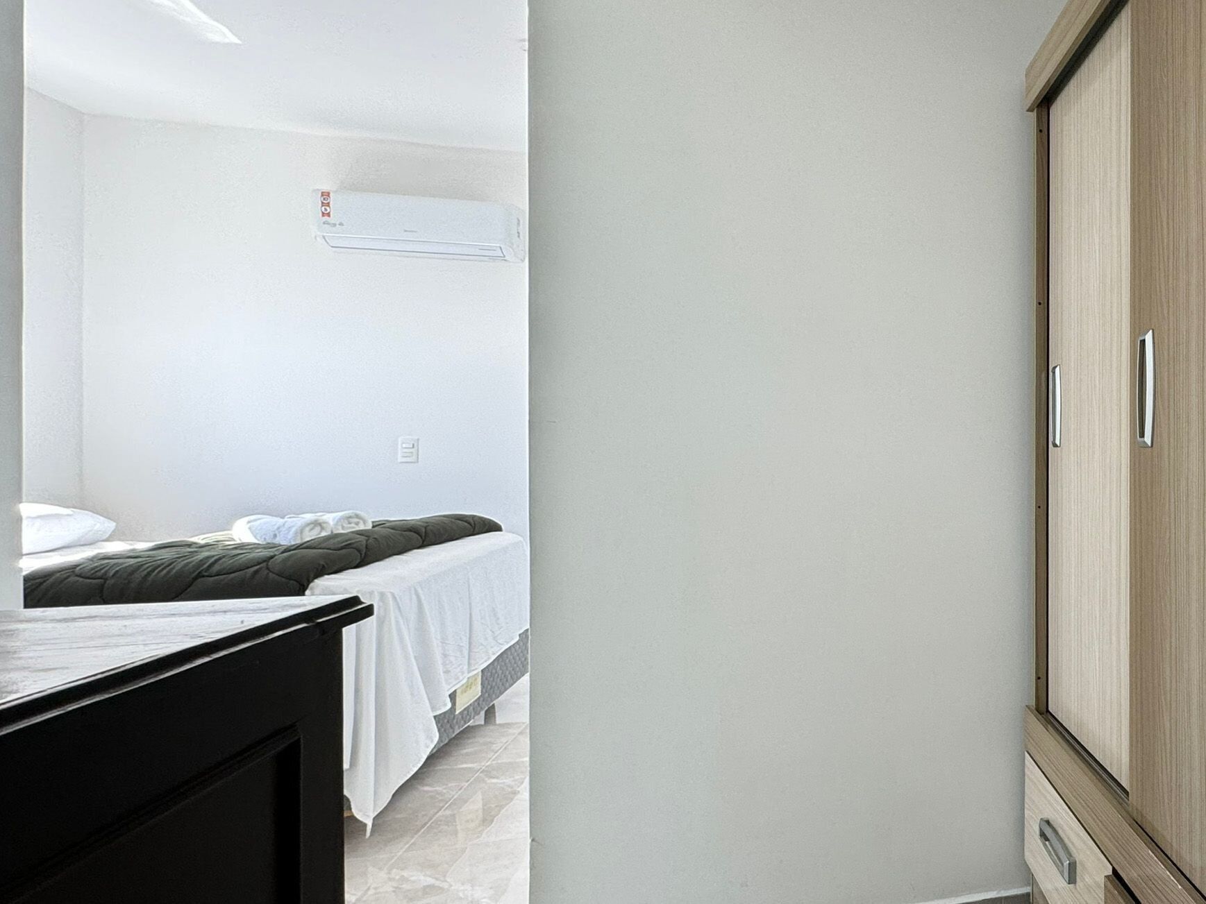 Ein Schlafzimmer mit einem Bett, einem Kleiderschrank und einer Wand-Klimaanlage.
