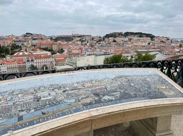 A cityscape with a prominent view of a hill and a bridge. - Charming City Center (Lisbon)