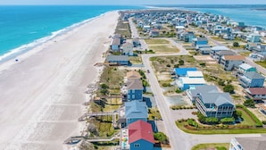 A coastal residential area with houses, a beach, and a road. - The Beachcomber by Topsail Realty (Holly Ridge)