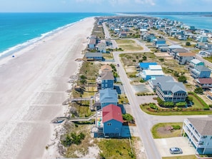 A coastal residential area with houses, a beach, and a road. - The Beachcomber by Topsail Realty (Holly Ridge)