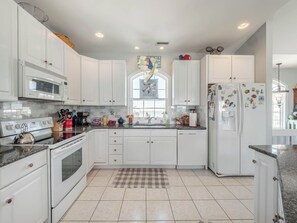 Enjoy cooking in this well-equipped kitchen with a stainless steel range, oven, and microwave.