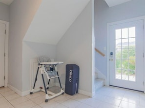 A room with a white door, a window, and a baby walker. - Serendipity by Topsail Realty (Holly Ridge)