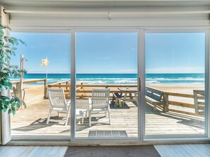 A beachside deck with wooden chairs and a table, overlooking the ocean. - Mamaw's Spot by Topsail Realty (Holly Ridge)