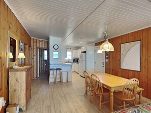 Enjoy meals in this kitchen with a dining table and chairs, a refrigerator, sink, and stove.