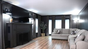 Una sala de estar moderna con chimenea, un sofá y un televisor.