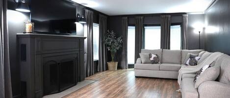 A modern living room with a fireplace, a sofa, and a television.