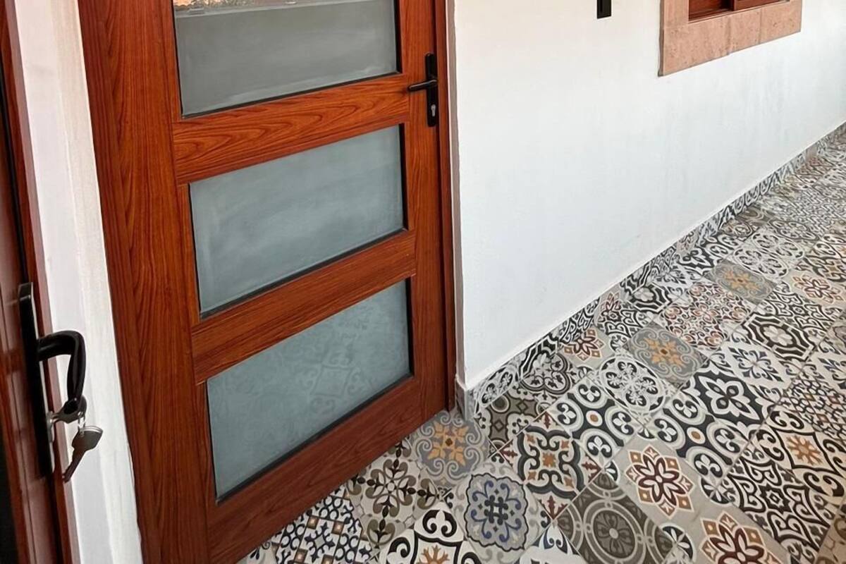 A wooden door with frosted glass panels and a sign above it that reads "Madbud."