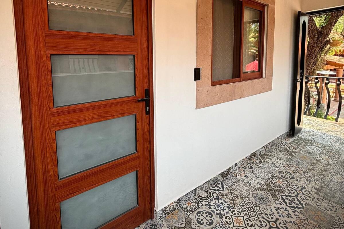 A wooden door with frosted glass panels, a small window with a wooden frame, and a sign above the door that reads "Valencia."
