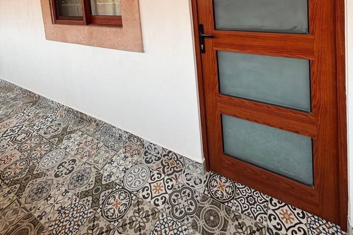 A wooden door with frosted glass panels, a small window with a wooden frame, and a wall-mounted sign reading "Balbao".