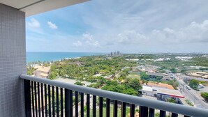 Un balcon offrant une vue sur le paysage urbain de la côte, avec ses bâtiments et sa végétation.