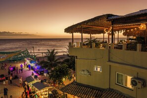 Ein Strandgrundstück mit überdachter Sitzgelegenheit, einer Bar direkt am Strand und Blick aufs Meer.