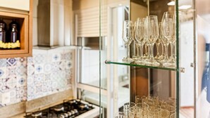 A kitchen with a glass display case holding wine glasses and bottles. - Resid. Clube Mar Grosso-Laguna - LAG905 (Laguna)